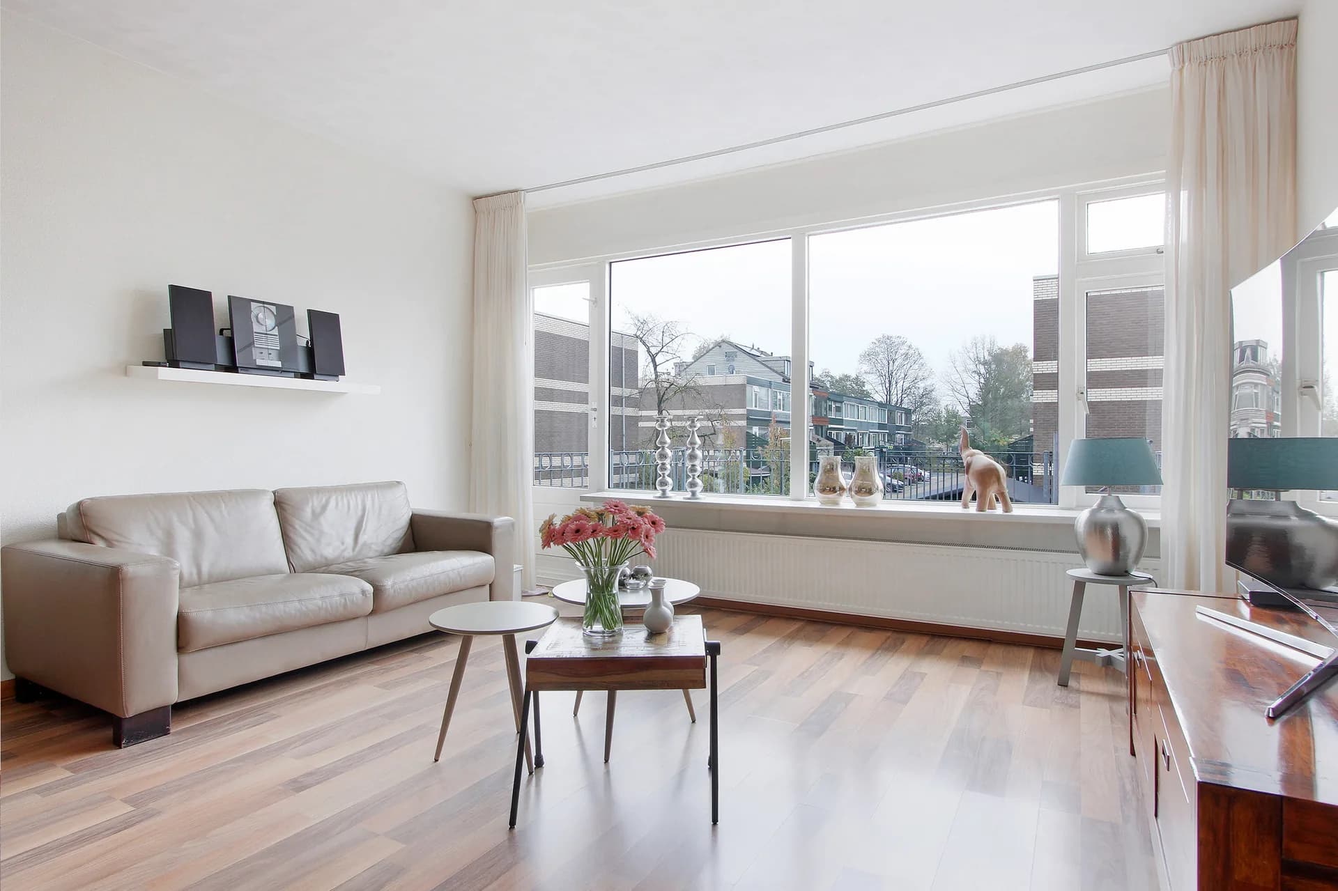 Living room after editing, with a brighter sofa and clearer buildings through the window