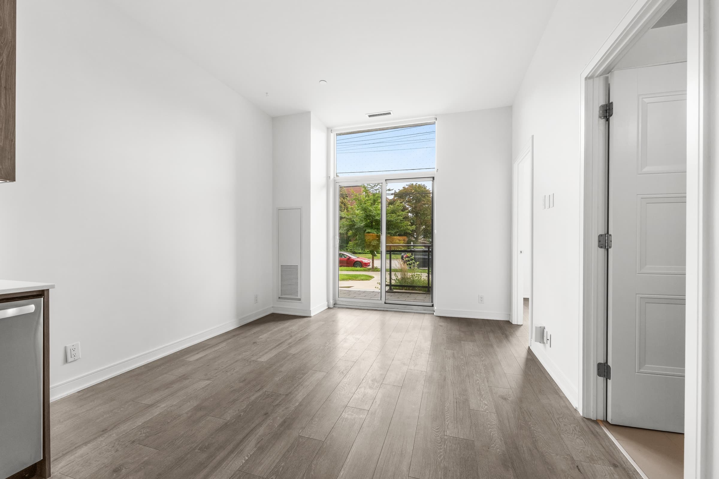 Empty living room before virtual staging, showing the original flooring, windows and fixed architectural features