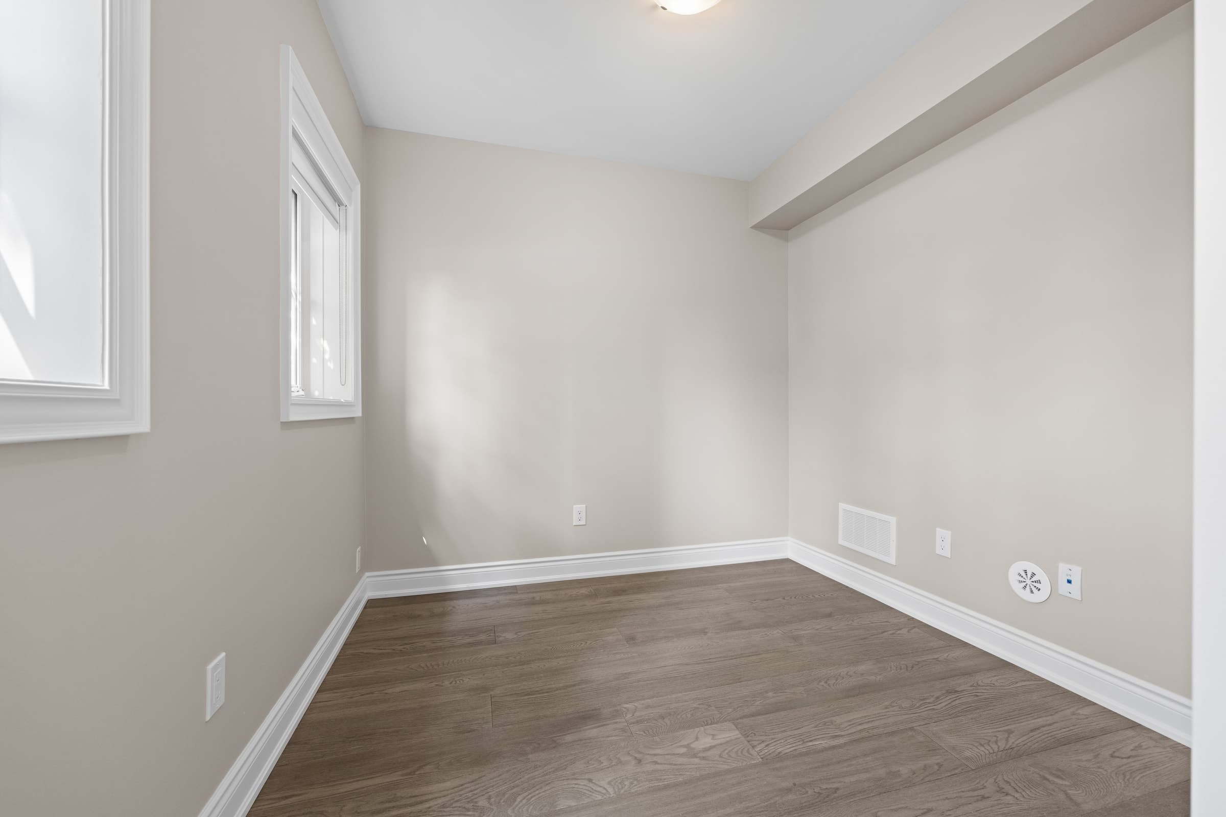 Empty room before virtual staging, showing the original walls, windows and flooring