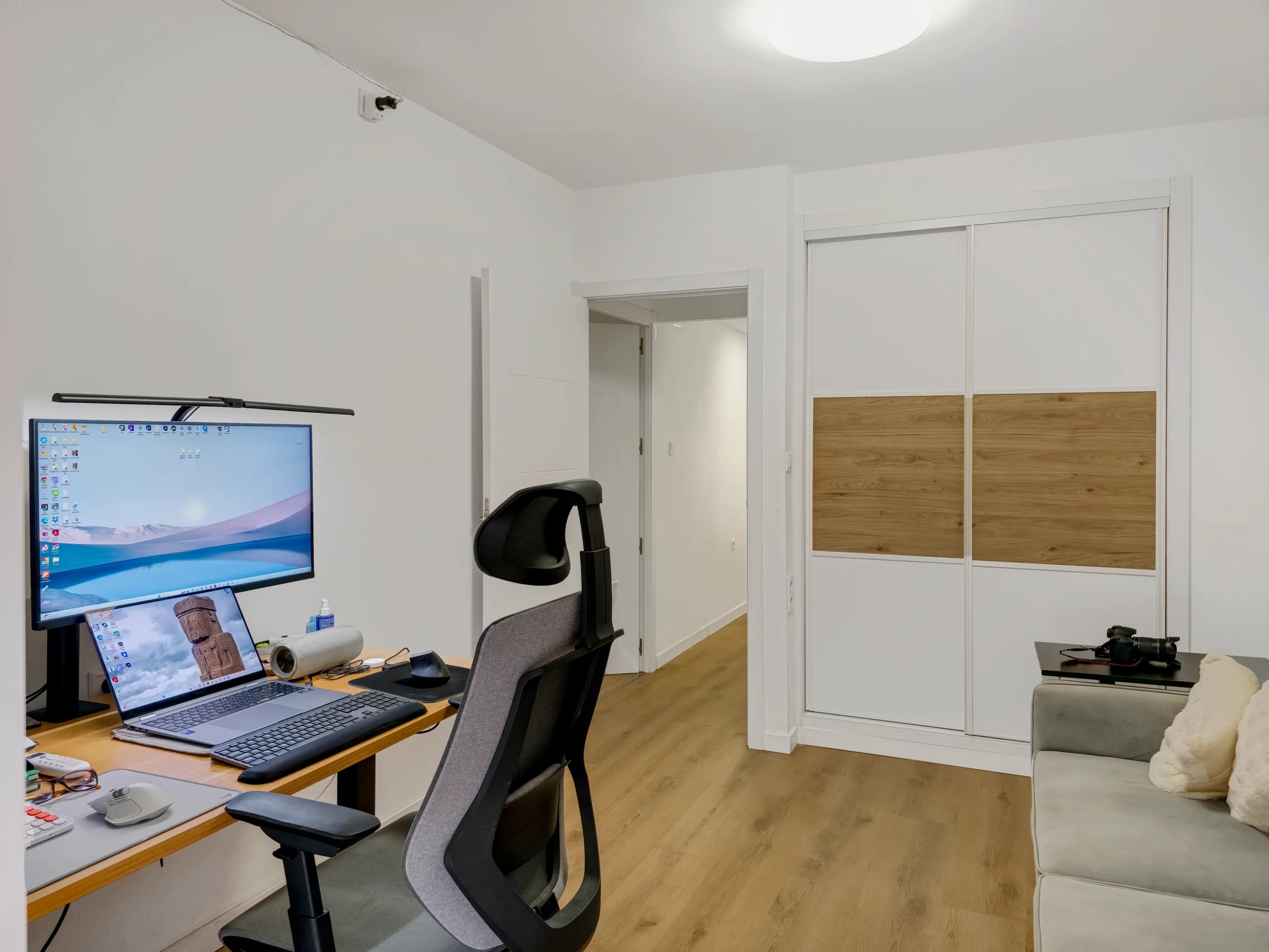 After image enhancement: Open-plan living room interior with neutral walls, seating, and natural daylight